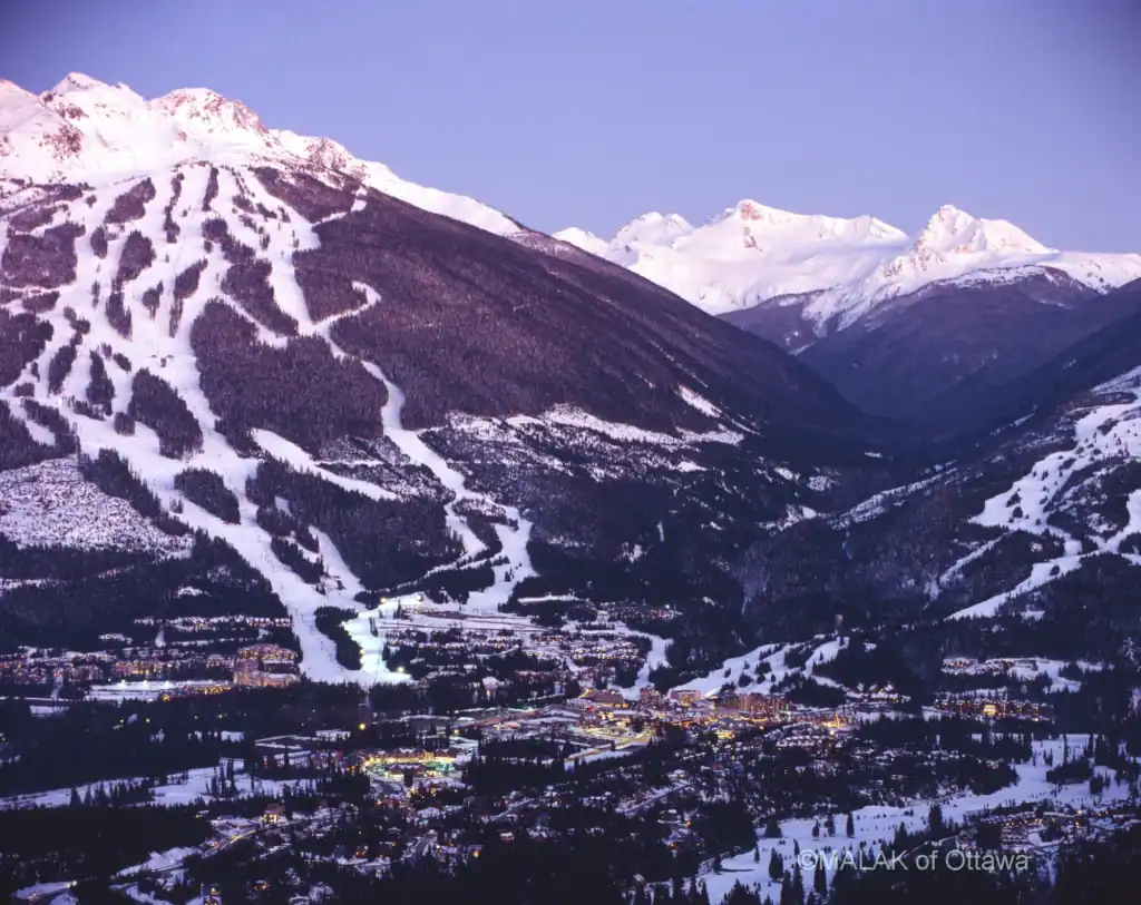 Mountain ski resort with snow trails and a cozy town in the valley.
