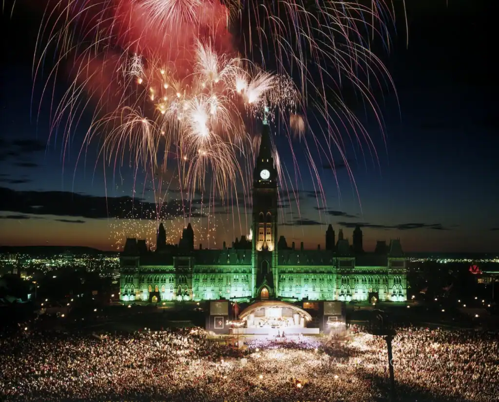 Fireworks illuminate the night sky above Parliament Hill in Ottawa during a festive event.