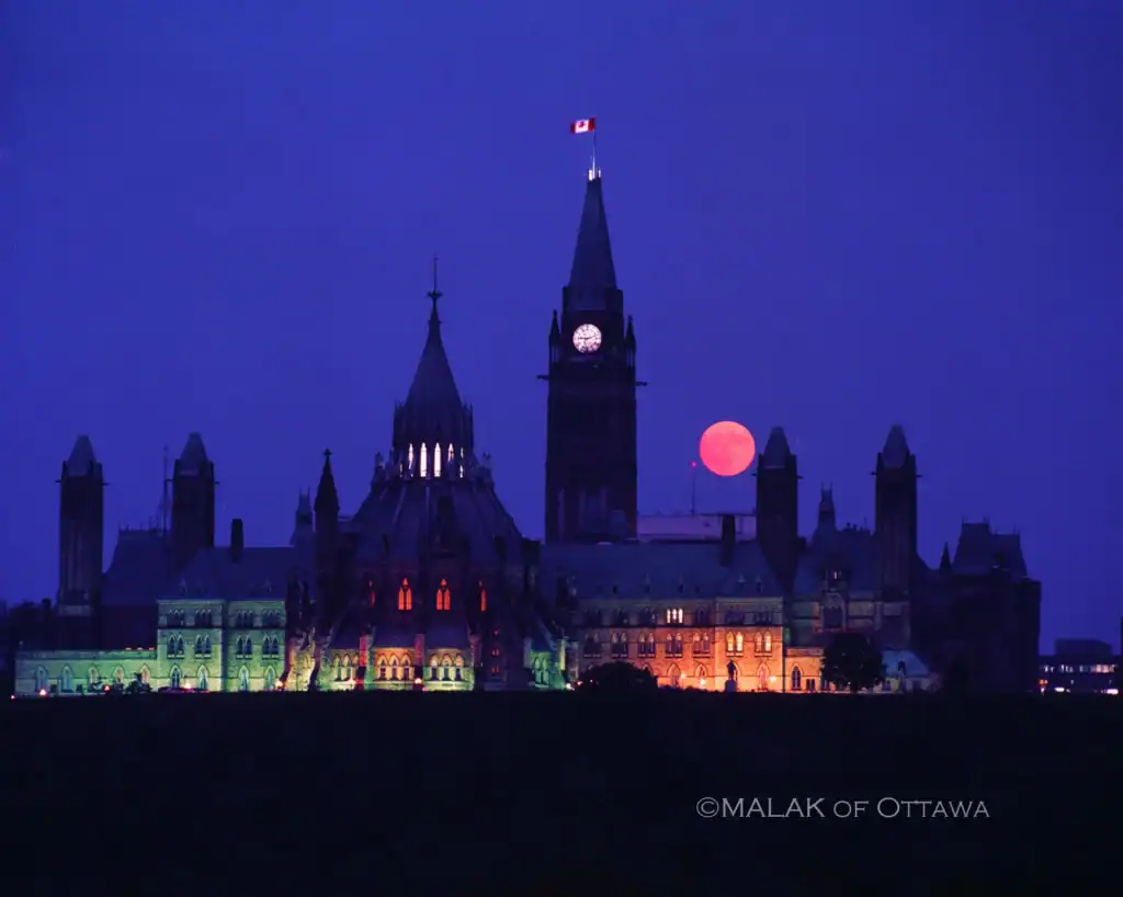 Parliament Hill illuminated with a full moon in Ottawa, Canada.