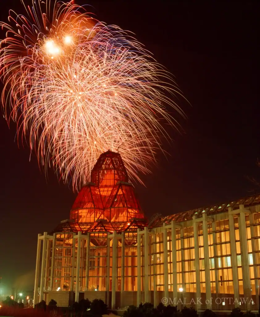 Fireworks illuminate the night sky above Malak of Ottawa building.