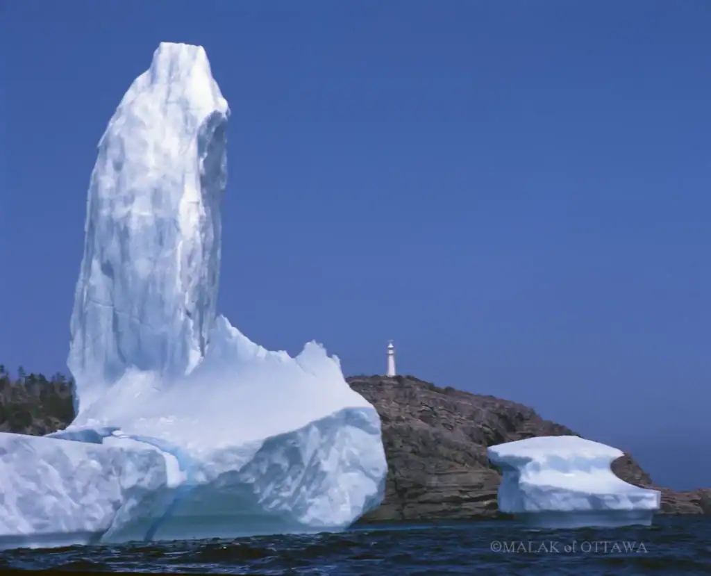 Iceberg and rocky coastline at Malak of Ottawa, showcasing natural Arctic beauty.