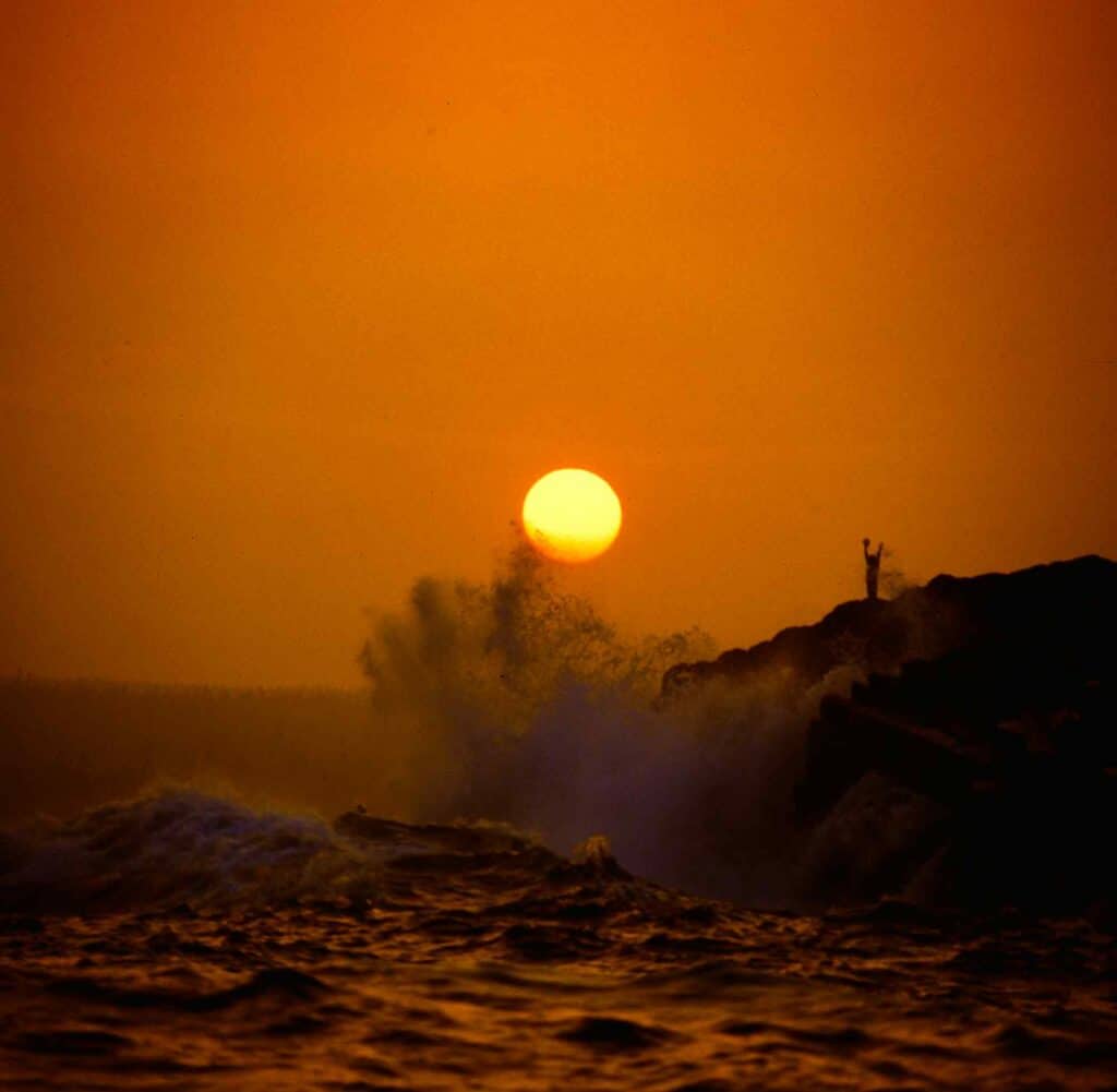 Beautiful sunset over ocean with waves hitting rocks at Malak of Ottawa.