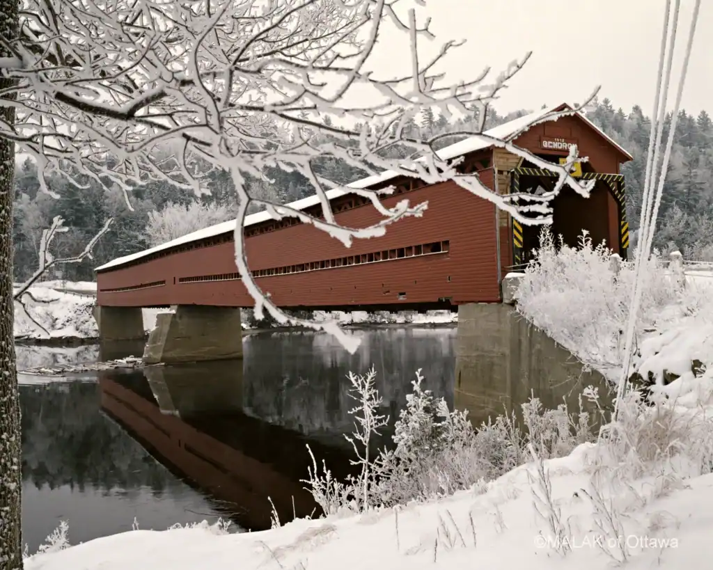 Covered bridge in Ottawa during winter snowfall.