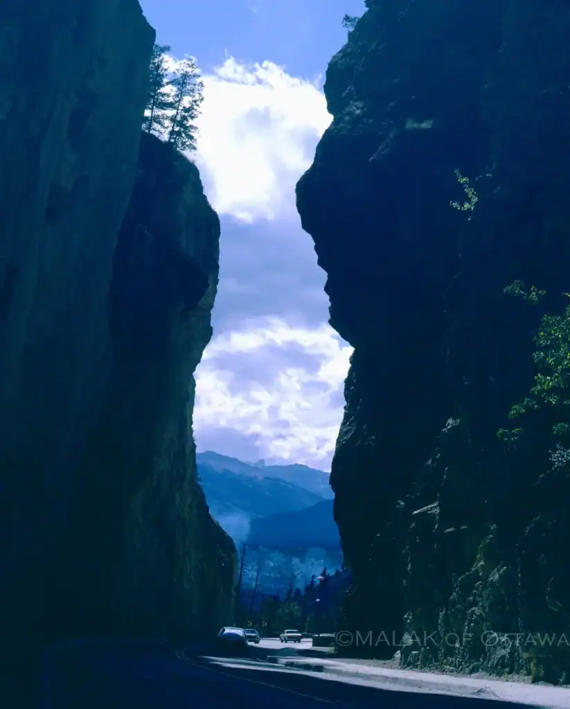 Mountain canyon with a road and vehicles, scenic landscape, Malak of Ottawa.